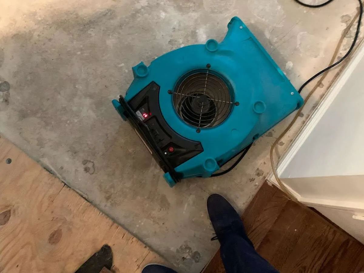 Air mover drying subfloor during Commercial Water Damage Restoration in Chapel Hill